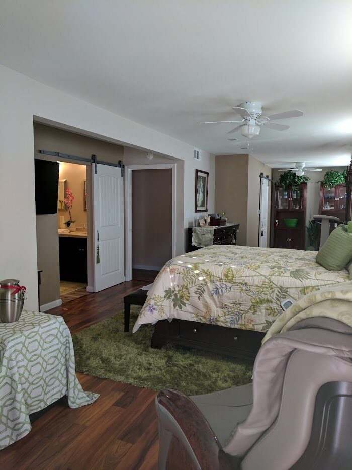 Bedroom with freshly painted light walls, a sliding barn door to the bathroom and two ceiling fans