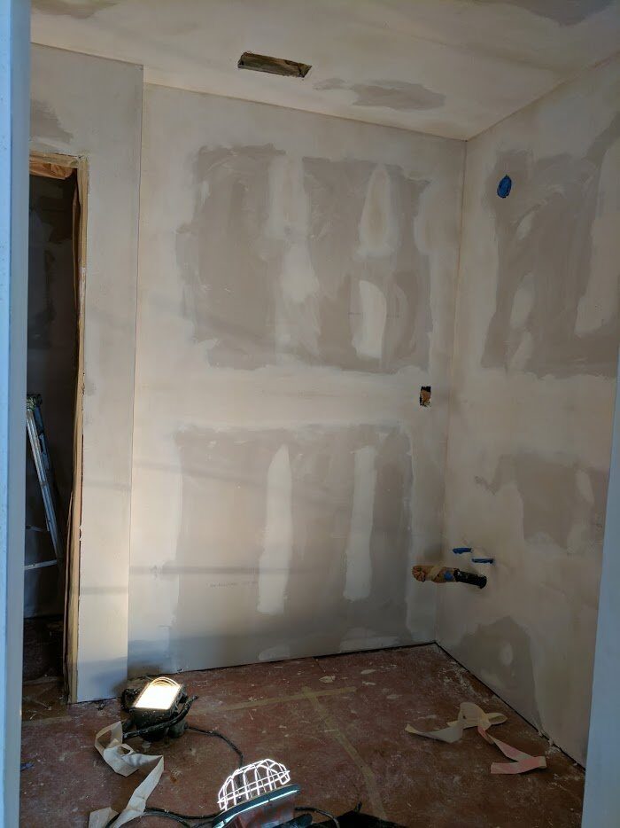 Drywall patches taped and mudded on the walls of a small room